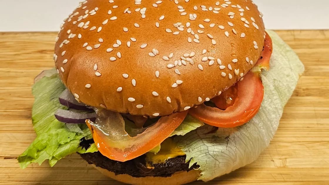 Nonkel Burger: rundvleesburger met sla, tomaat, rode ui en kaas op een sesambroodje